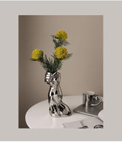 مزهرية فنية أوروبية حديثة لجسم الإنسان من السيراميك مطلي باللون الفضي بترتيب زهور لتزيين سطح المكتب والمفروشات